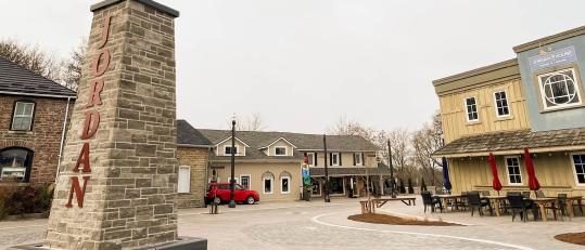 Picture of Jordan Village downtown square with stores and Pillar